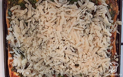 Достаньте форму из холодильника. Тесто посыпьте немного сыром. Выложите равномерно начинку из обжаренной грудинки, моркови и кабачка. Сверху распределите заливку. Отправьте киш духовку, разогретую до 200 °C, и выпекайте 45 минут. Через 25 минут с начала выпекания достаньте форму и посыпьте оставшимся сыром. Отправьте в духовку и выпекайте до готовности.