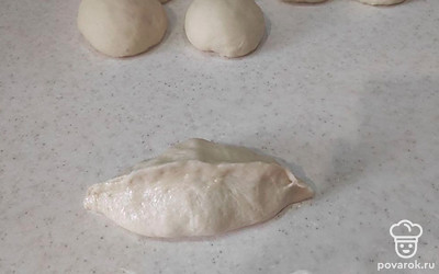 Перед работой с тестом смажьте руки и рабочую поверхность растительным маслом, чтобы тесто не липло. Выложите тесто на рабочую поверхность, разделите его на равные части и скатайте шарики (примерно 18 шариков). Оставьте тесто немного подойти около 5-10 минут.