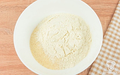 В глубокой миске смешайте все сухие ингредиенты: просеянную муку с разрыхлителем, манку и сахар, перемешайте.