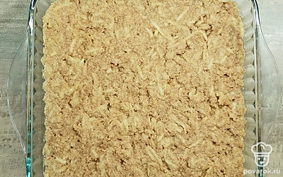 Выложите тесто сверху на дольки яблок в форме, разровняйте ложкой и поставьте форму в духовку. Выпекайте 30 минут до сухой лучины. Выньте из духовки и дайте немного остыть.