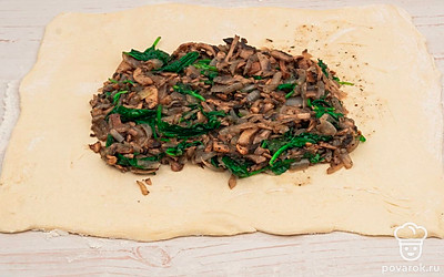 Раскатайте слоеное тесто и выложите начинку в центр.