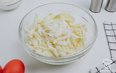 Нашинкуйте капусту, добавьте соль и помните капусту руками.