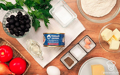 Достаньте сардины и маслины из банки, чтобы они немного просохли. Остудите воду и масло, почистите лук и чеснок, вымойте помидоры. Снимите кожицу с помидоров, нарежьте их, как и лук, кубиками, чеснок измельчите. Натрите на мелкой терке сыр. Зелень для подачи вымойте, обсушите на бумажных полотенцах и мелко нарежьте. Приготовьте жаропрочную форму.