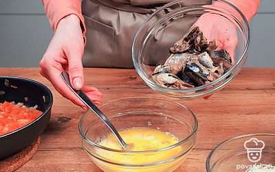 Приготовьте начинку. Обжарьте помидоры, лук и чеснок на растительном масле 5-7 минут до золотистого цвета и снимите с плиты. В отдельной емкости взбейте яйца, добавьте сардины и разомните рыбу на небольшие кусочки, посолите и поперчите. Добавьте овощную обжарку и тщательно перемешайте.