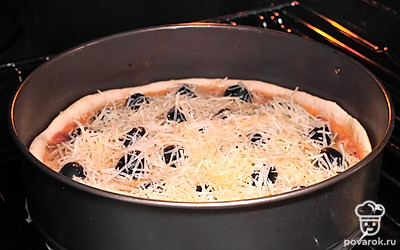 Испеките пирог. Включите духовку на 180 градусов. Переложите начинку в тесто, добавьте маслины, тертый сыр и равномерно распределите его по поверхности. Выпекайте киш в течение 30-40 минут.