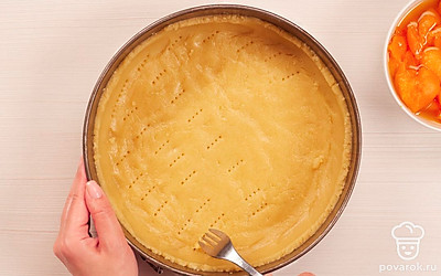 Испеките основу пирога. Тесто руками распределите по дну формы, сформируйте бортики. Поместите форму в разогретую до 200 градусов духовку на 20 минут.