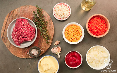 Морковь, лук и чеснок очистите и нарежьте мелкими кубиками. Томатную пасту смешайте с теплой водой до однородности. Снимите соцветия и листья со стеблей тимьяна (стебли не понадобятся). Закипятите воду или бульон. Слейте жидкость от кукурузы и хорошо просушите зерна. Очистите картофель и несколько раз промойте в холодной воде. Доведите молоко до кипения, растворите в нем сливочное масло и хорошенько перемешайте. Натрите сыр на средней терке. Разогрейте духовку до 200°C, подготовьте высокую тефлоновую форму для пирога, сковороду с высокими стенками и фольгу.