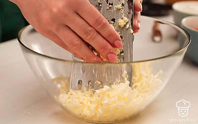 Приготовьте тесто: натрите на терке замороженное сливочное масло, добавьте сахар, яйцо и хорошенько перемешайте. Просейте в смесь муку с разрыхлителем и перемешайте (будет удобнее перемешивать руками).