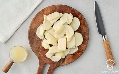 Разрежьте яблоки пополам, удалите из них сердцевину с семенами. Очистите яблоки от кожуры и нарежьте их полукруглыми дольками толщиной около 6-7 мм. 