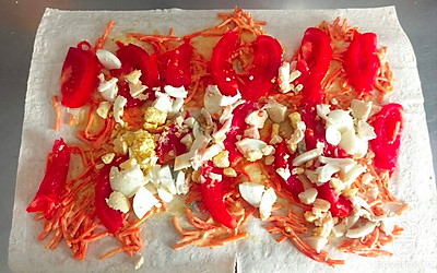 Выложите яйцо и ломтики помидора, сверните лаваш. Дайте рулету постоять 30 минут, чтобы лаваш пропитался начинкой и стал мягче.