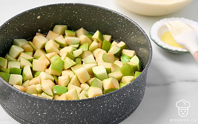 Разогрейте духовку до 190°C. Застелите дно формы для выпечки пергаментной бумагой. Промажьте бумагу растительным маслом с помощью силиконовой кисточки. Разложите кубики яблок ровным слоем по дну формы.