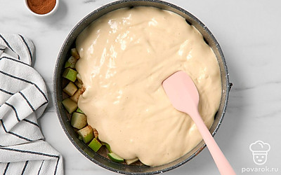 Залейте яблоки тестом. Аккуратно потрясите форму, чтобы тесто равномерно распределилось по кубикам яблок.