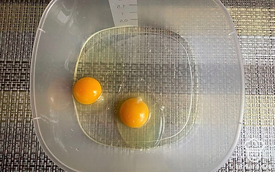 Разбейте в емкость 2 куриных яйца.