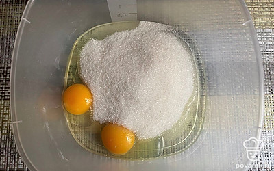 Всыпьте сахар к яйцам.