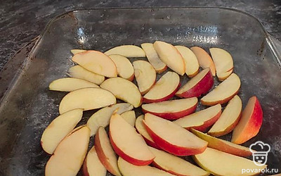 Нарезать яблоки, выложить в смазанную форму.