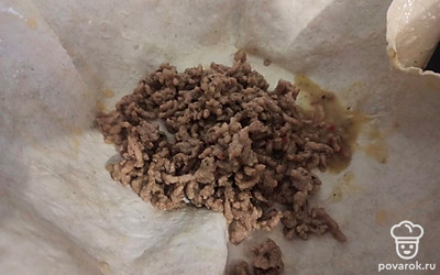 Уберите фарш со сковороды, добавьте подсолнечное масло и выложите лаваш. В центр лаваша выложите обжаренный фарш.