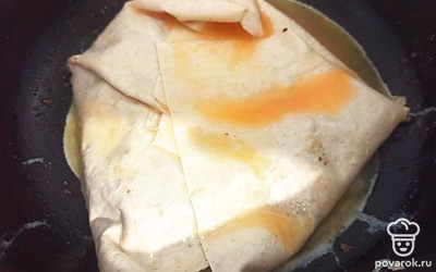 Заверните лаваш и полейте остатками взбитого яйца. Обжарьте с двух сторон по 5 минут.