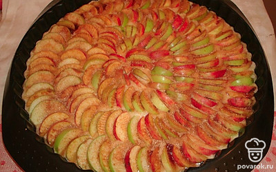 У яблок убрать сердцевины, нарезать их тонкими ломтиками и разложить поверх теста. Посыпать сахаром и корицей.