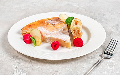 Разрежьте шарлотку на порционные кусочки, украсив каждый малиной и кусочками яблока. Перед подачей посыпьте сахарной пудрой. 