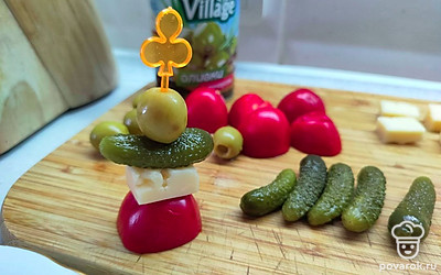 На каждую шпажку насадите оливку, пикули, сыр и черри. 