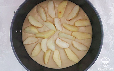 Очищенные яблоки нарежьте на тонкие дольки, форму для выпечки застелите пергаментной бумагой и выложите в нее половину теста. Яблочные дольки выложите поверх теста, приправьте их небольшим количеством корицы, залейте фруктовую прослойку оставшимся тестом и снова выложите яблоки. Собранную шарлотку отправьте в духовой шкаф, разогретый до 180 °С, выпекаться в течение 40-50 минут до готовности.