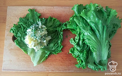 Выложите начинку в центр каждого листа салата и заверните.