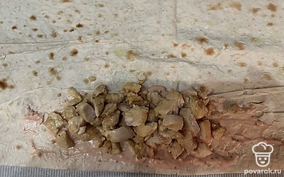 Соберите шаверму. Край половины лаваша подверните и смажьте соусом. Сверху выложите обжаренное филе.