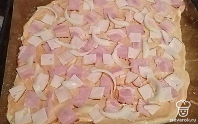 Выложите лук на тесто.