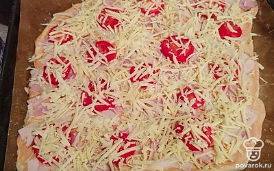 Посыпьте пиццу тертым сыром и поставьте в предварительно разогретую до 180 градусов духовку на 20 минут.