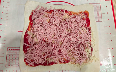 Вареную колбасу натрите на крупной терке. Равномерно распределите поверх сыра.