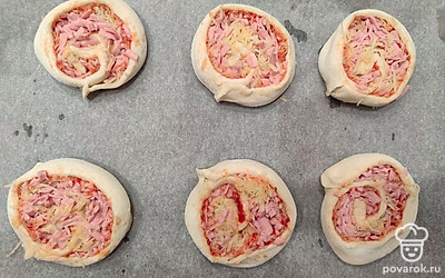 Выстелите пергаментную бумагу на противень. Выложите на нее круглые заготовки. Немного приплюсните каждую лепешечку ладонью.