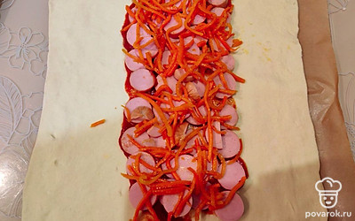 Выложите морковь на сосиски. 