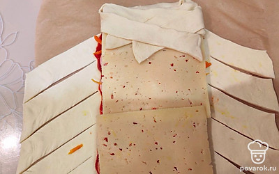 Подогните верхний край теста. Берите по одной полосе и скрещивайте их. 