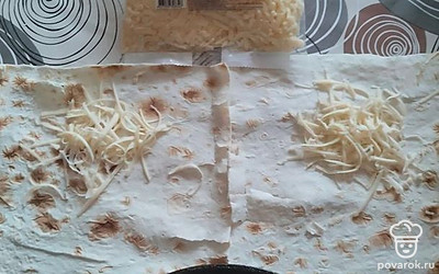 Лист тонкого лаваша нарежьте на прямоугольники. Выложите на один край лаваша натертый твердый сыр. Сверху положите фарш с грибами и аккуратно, но плотно заверните лаваш с начинкой.