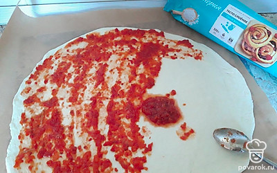 Смажьте тесто 2 столовыми ложками кетчупа или аджики.