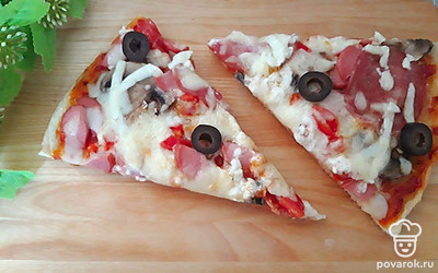 Нарежьте пиццу. Подавайте порционно.