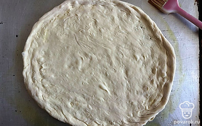 Растяните тесто в круг, формируя небольшие бортики. 