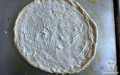 Основу из теста смажьте сливочным соусом. 