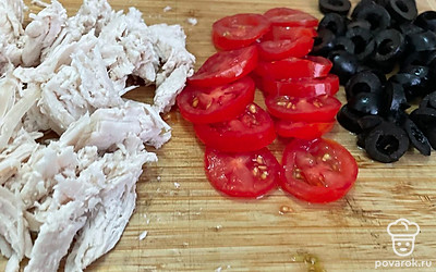 Нарежьте черри, маслины и куриное филе.