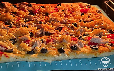 Сверху обильно посыпьте тертым сыром. Выпекайте пиццу в разогретой до 180 градусов духовке 8-10 минут.