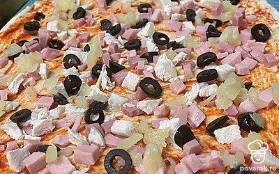 Ананасы нарежьте кубиком. Равномерно выложите все ингредиенты на основу для пиццы.