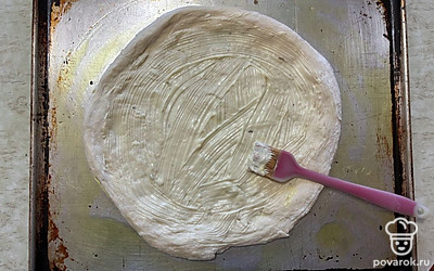 Основу из теста смажьте сливочно-чесночным соусом.