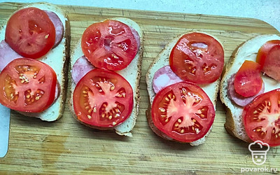 Затем выложите кружочки помидоров. 