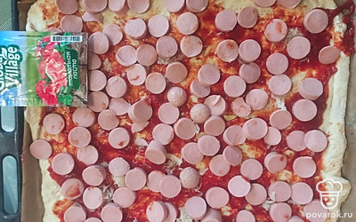 Выложите нарезанные сосиски. 