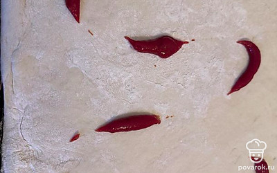 Тесто посыпьте мукой и раскатайте в тонкий большой пласт. Добавьте кетчуп, смажьте основу пиццы.