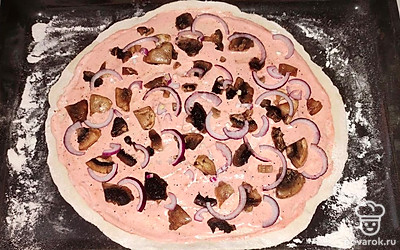 Сверху на тесто выложите нарезанные грибы и репчатый лук.
