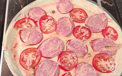 Далее разложить по тесту нарезанный помидор, сверху слой смазать смесью из майонеза и кетчупа. 