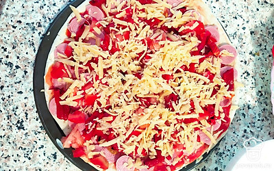 Протрите сыр на крупной тёрке и посыпьте им пиццу. Отправляем в духовку на 10 минут при температуре 180 градусов.