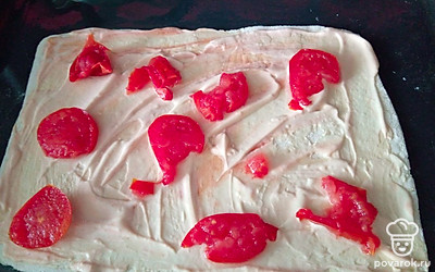 Смешайте кетчуп и майонез и смажьте тесто. Помидорку нарежьте и выложите на пиццу. Разогрейте духовку до 200 градусов.