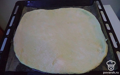 Тесто раскатать на большую круглую лепешку. Выложить на противень смазанный маслом.